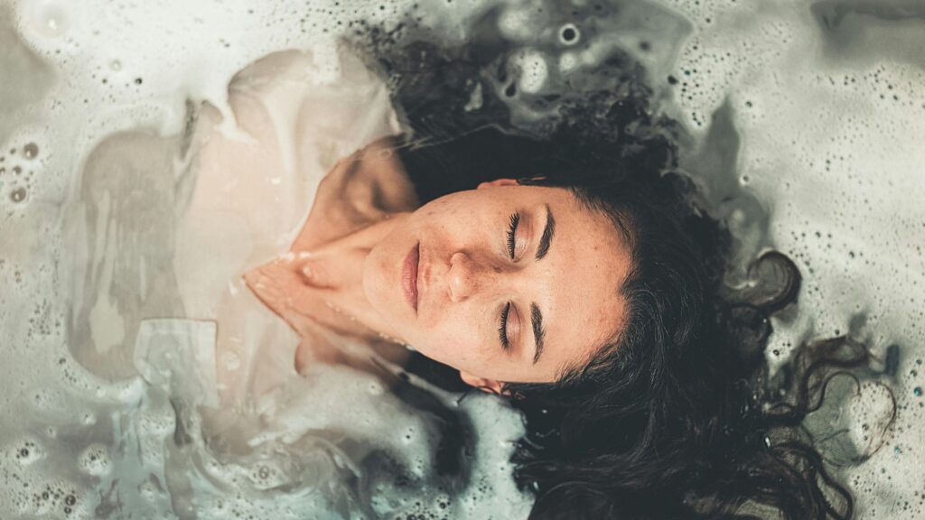 A woman meditating in a bathtub after physiotherapy session for her mental health growth