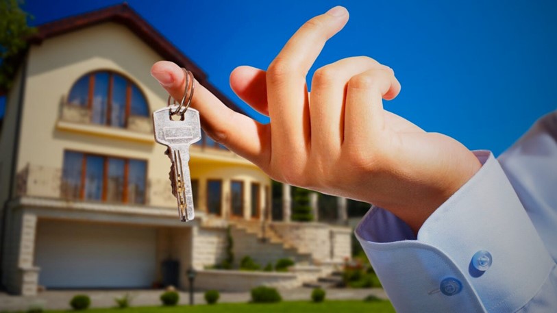 A person holding a key to rent a home, symbolising secure rental property